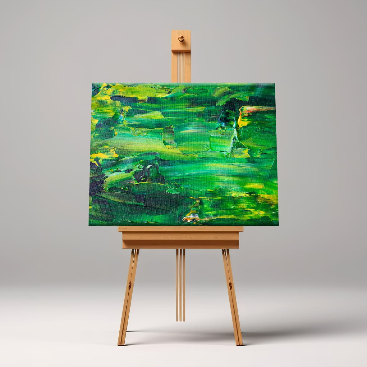 Abstract green canvas painting displayed on a wooden easel with smooth gradient background.