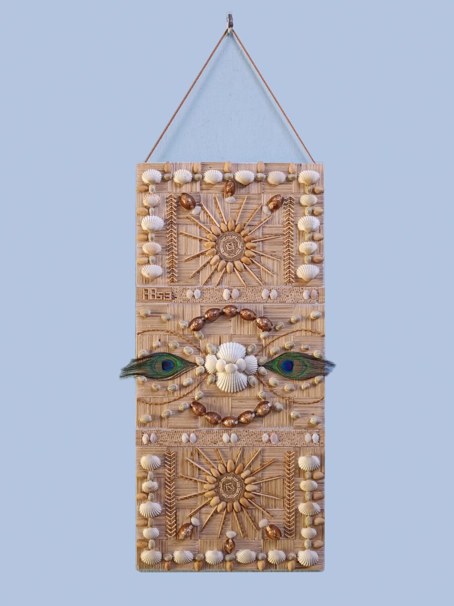 Handcrafted dual-purpose wall hanging and greeting card made with shells, toothpicks, seeds, and peacock feathers, featuring a sun motif and abstract eyes.