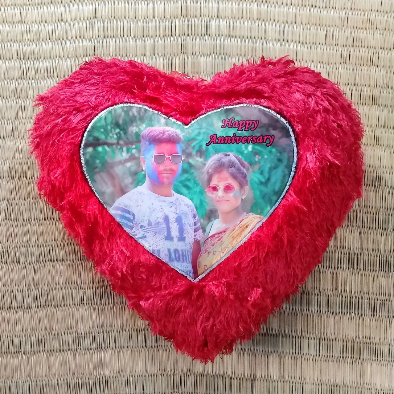 Red heart-shaped fluffy personalized cushion with a printed anniversary photo of a couple and the text "Happy Anniversary."