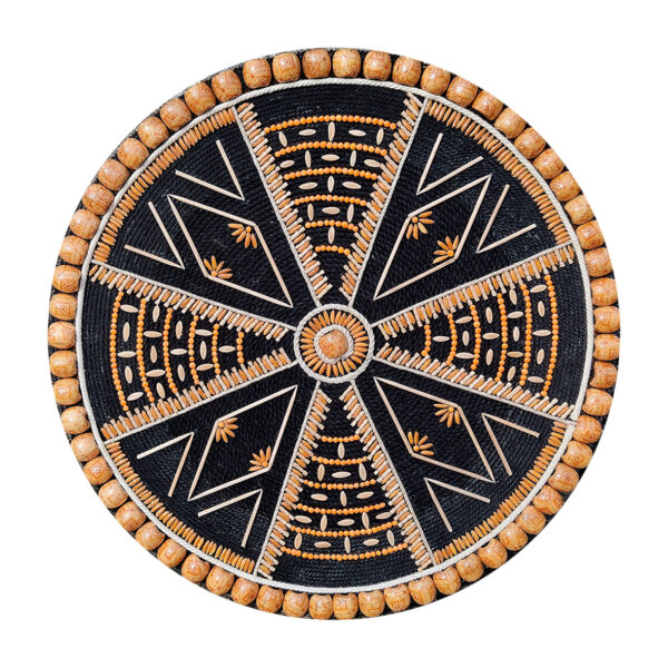 A circular handmade wall hanging titled "Dhono Dhanno", crafted using paddy seeds, lentils, wooden beads, and jute thread on a black cotton rope and MDF board base, in a symmetric mandala pattern.