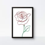 A handmade "Blooming Rose" rope art featuring a vibrant red rosebud and a green stem with a leaf, mounted in a sleek black frame against a plain white wall.