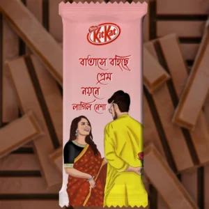 A pre-designed soft pink chocolate wrapper featuring the famous lyrical Bengali Quote: "Batase Bohiche Prem Noyone Lagilo Nesha." This Romantic themed KitKat design illustrates a couple where the man in a yellow panjabi is hiding a rose behind his back for the woman in a gorgeous saree, capturing a sweet surprise moment.