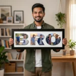 A smiling young man holding a classic black rectangular Upahar18 Brother Photo Frame featuring a custom-printed photo collage designed inside the word BRO on a clean white background.
