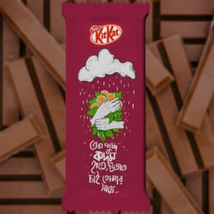 A customized maroon KitKat chocolate wrapper featuring a Nestlé KitKat logo, a hand-drawn illustration of hands holding a bouquet of Kadam flowers under a rainy cloud, and Bengali typography.