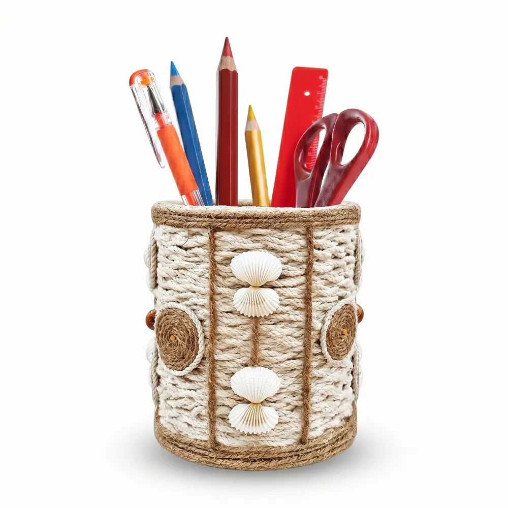 Studio photograph against a white background of a handmade rope pen stand with white seashells and brown twine circles, containing colorful pencils, pens, a red ruler, and red scissors.