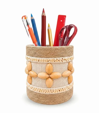 Studio shot on a white background of Upahar18 Handmade Eco-Friendly Rope Base Pen Stand filled with office stationery. The image highlights the detailed horizontal rows of mini bamboo beads framing a central pattern of cream rope and smooth wooden seed flowers.