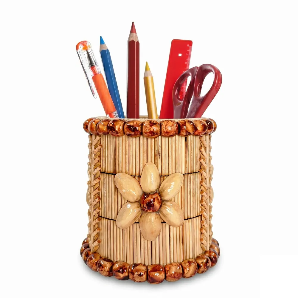 Alt Text: An isolated product shot of the Upahar18 handmade pen stand against a plain white background. The cylindrical holder features an artistic flower motif made from pistachio shells, vertical columns of thin natural wooden sticks, and prominent horizontal rings of polished brown wooden beads decorating both the top and bottom rims. It contains colored pencils, a ruler, and scissors.