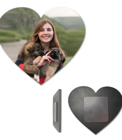 A multi-angle product display showcasing a heart-shaped personalized MDF fridge magnet with a photo of a smiling woman holding two small puppies. Below the main image, the side profile highlights its sleek thickness, and a full back view displays the solid dark wooden base with a powerful square magnetic sheet attached in the center by upahar18.