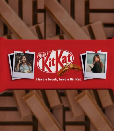 A customized red kitkat bar from upahar18 wrapped in a personalized photo printed design that features two separate polaroid pictures pinned to the cover.