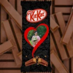 An elegant black swirl patterned upahar18 customized kitkat chocolate wrapper, featuring a personalized photo printed image inside a large red brush-stroke heart frame.