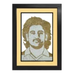 An elegant rope craft portrait of MS Dhoni featuring detailed jute artwork, enclosed in a premium black frame with a sophisticated cream-colored inner mount border.
