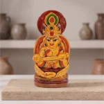 Designer compact Terracotta Maa Saraswati idol by upahar18 displayed beautifully on a raw wooden block inside a minimalist interior studio setup, crafted in Krishnanagar.