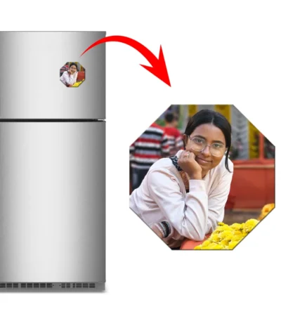 A marketing display showing a silver kitchen refrigerator with an eight-sided octagon personalized flexible photo magnet stuck on it. A sharp red arrow highlights a large close-up of the octagon magnet on the right, showing a customized picture of a young woman with glasses smiling with her hand on her chin next to bright yellow flowers by upahar18.
