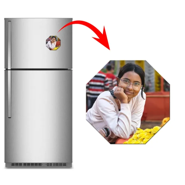 A marketing display showing a silver kitchen refrigerator with an eight-sided octagon personalized flexible photo magnet stuck on it. A sharp red arrow highlights a large close-up of the octagon magnet on the right, showing a customized picture of a young woman with glasses smiling with her hand on her chin next to bright yellow flowers by upahar18.