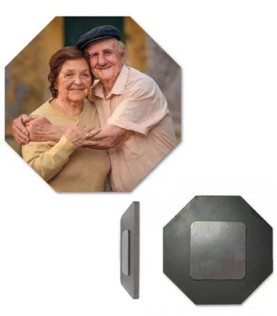 A product presentation image of an eight-sided octagon-shaped custom MDF photo fridge magnet, featuring a personalized picture of an elderly couple smiling and hugging. The display includes a slim side-view perspective and a separate back-view image showing the dark matte-finished wooden octagon base with a silver-grey square magnet in the middle by upahar18.