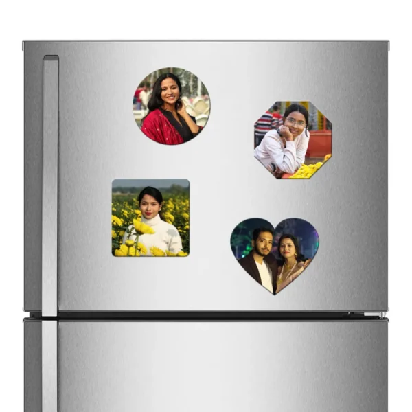 A straight front view of a stainless steel refrigerator door decorated with a combo set of four different shaped custom flexible photo fridge magnets, including a round magnet showing a woman in a red dupatta, an octagon magnet showing a woman with glasses resting her chin on her hand, a square magnet with a woman in a yellow mustard field, and a heart-shaped magnet displaying an Indian couple smiling together at night, all featuring vibrant personalized photos by upahar18.