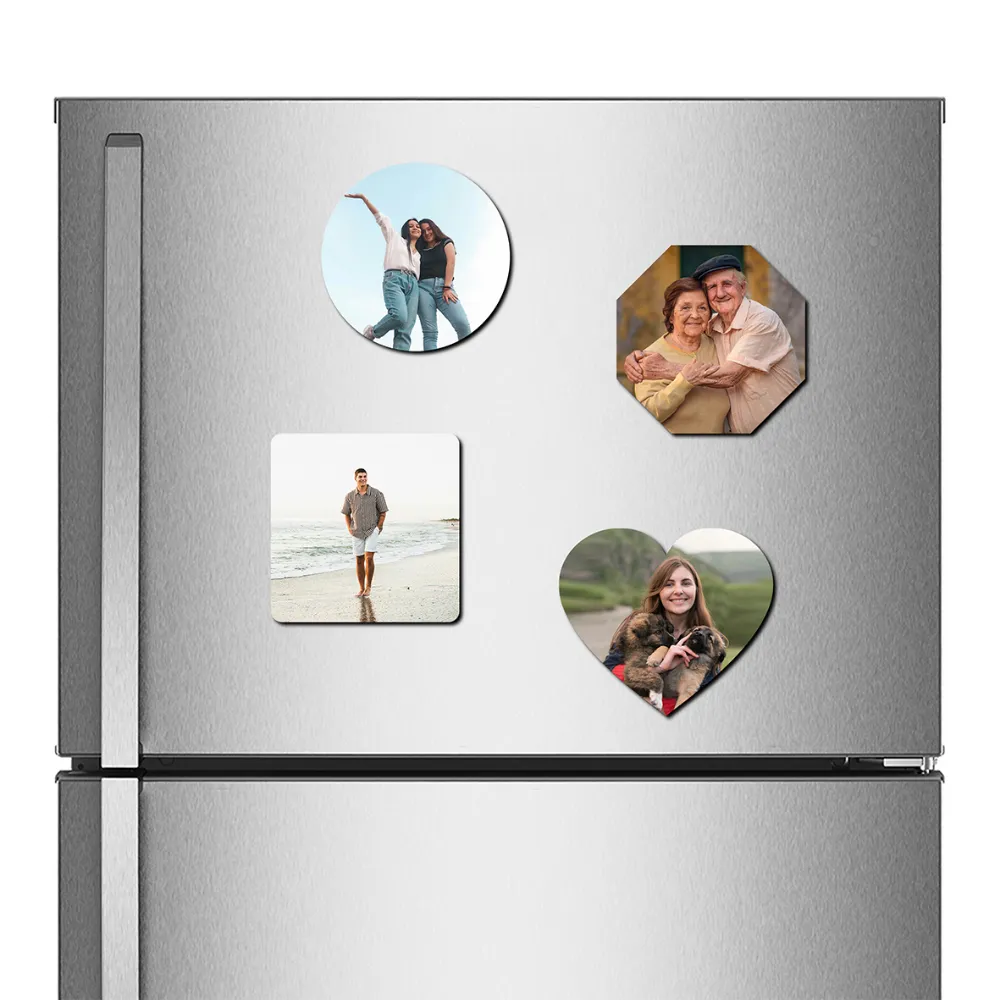 A straight front view of a stainless steel refrigerator door decorated with a combo set of four different shaped custom MDF photo fridge magnets, featuring a round magnet with two women, an octagon magnet with an elderly couple, a square magnet with a man on a beach, and a heart-shaped magnet with a woman and puppies, all printed with vibrant personalized photos by upahar18.
