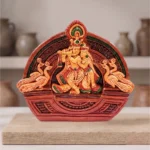 Designer Terracotta Radha Krishna idol by upahar18 displayed beautifully on a wooden block inside a minimalist interior studio setup, made in Krishnanagar.