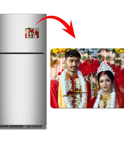 A product advertisement layout displaying a double-door grey refrigerator holding a horizontal rectangular custom flexible photo magnet. A red arrow leads to a larger widescreen view of the rectangle magnet, displaying a personalized Indian wedding photo of a bride and groom in traditional red outfits and floral garlands by upahar18.