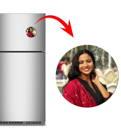 A clean product showcase containing a brushed metallic refrigerator with a circular personalized flexible photo magnet attached. An elongated red arrow marks a close-up circle view of the round magnet on the right, featuring a customized outdoor portrait of a smiling woman wearing a black top and a red traditional dupatta by upahar18.