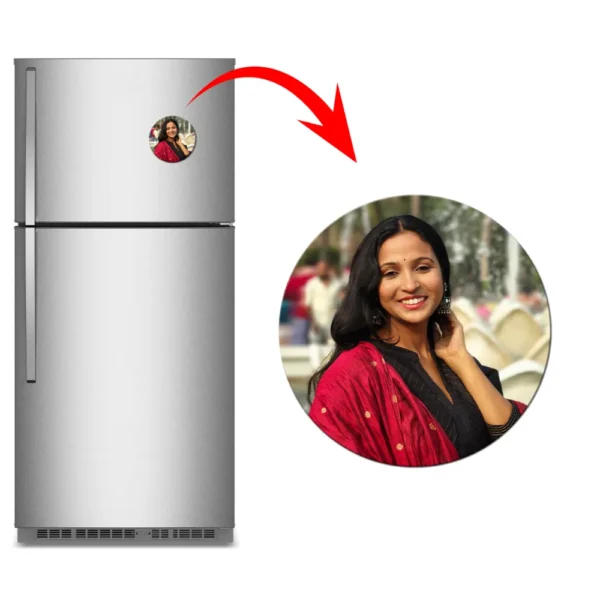 A clean product showcase containing a brushed metallic refrigerator with a circular personalized flexible photo magnet attached. An elongated red arrow marks a close-up circle view of the round magnet on the right, featuring a customized outdoor portrait of a smiling woman wearing a black top and a red traditional dupatta by upahar18.