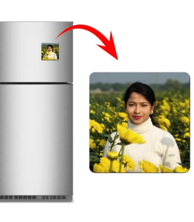 A product presentation featuring a double-door steel refrigerator on the left with a square personalized flexible fridge magnet attached to it. A large red curved arrow points from the fridge to a close-up view of the square magnet on the right, displaying a customized photo of a smiling young woman in a white turtleneck sweater standing in a vibrant field of yellow mustard flowers by upahar18.