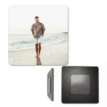 A square personalized MDF photo fridge magnet shown from three viewpoints against a white backdrop. The front square depicts a customized photo of a man walking on a sandy beach, the side view shows the clean layered wood thickness, and the back profile shows a dark square wooden board mounted with a flat metallic magnetic sheet by upahar18.