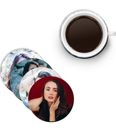 A top view of a stack of four round coasters from upahar18 printed with individual female portraits, paired with a white ceramic cup filled with black coffee.