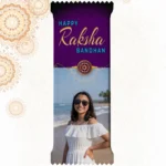 Customized Cadbury Dairy Milk by upahar18 with a purple customize design wrapper showing an English Rakhi greeting, a traditional rakhi thread illustration, and a real photo chocolate print of a smiling girl on a sunny beach.