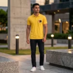 A male model posing outdoors in a bright yellow polo collar T-Shirt from upahar18 with a circular custom photo logo printed on the left chest.