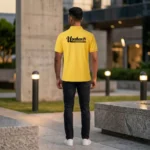 Back view of a male model wearing a yellow polo T-Shirt displaying the bold upahar18 brand name printed on the upper back.