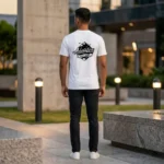 Back view of a male model wearing a white round neck T-Shirt from upahar18 showcasing a bold black adventure graphic printed on the center back.