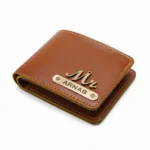 A studio shot from an isometric angle of a closed light brown faux Leather Wallet for men from upahar18, featuring neat contrast stitching, a metallic 'Mr.' charm, and a custom name metal strip printed with ARNAB against a seamless white background.