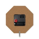 The rear view of an octagon upahar18 MDF clock showing its brown engineered fiberboard back, black quartz time-keeping mechanism, and a silver metal stand pin.