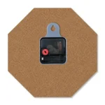 The back view of an octagonal upahar18 MDF clock showing its brown wood fiberboard back, a central black quartz movement box, and a built-in grey plastic wall-hanging slot.