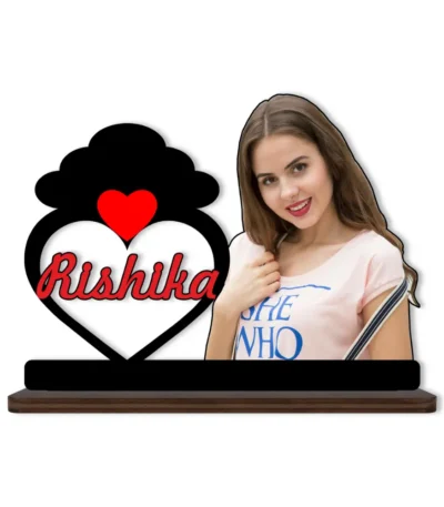 A high-definition printed MDF cutout standee by upahar18 featuring a personalized custom photo of a smiling woman next to a heart frame with a black cloud silhouette on top and the name "Rishika" printed inside, isolated on a white background.