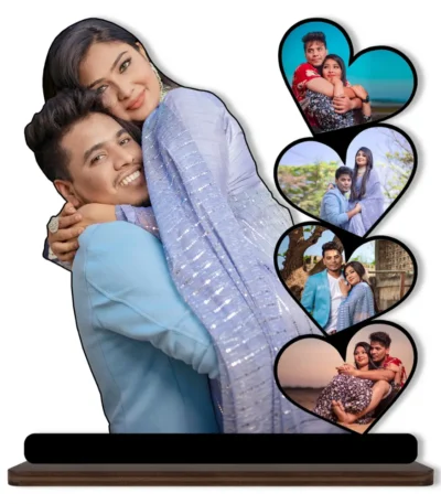 A high-definition printed MDF cutout standee by upahar18 featuring a personalized custom photo collage with a large main cutout of a hugging couple alongside four heart-shaped photo slots, isolated on a white background.