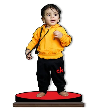 A cute personalized custom photo printed MDF cutout standee from upahar18 featuring a small toddler boy wearing a bright yellow hoodie and black sweatpants, isolated on a solid white background.
