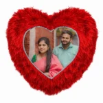 A close-up product shot of a personalized red heart-shaped fur cushion featuring a custom photo of a couple in traditional wear by upahar18.