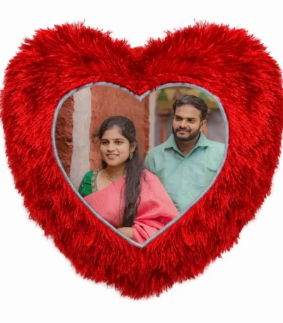 A close-up product shot of a personalized red heart-shaped fur cushion featuring a custom photo of a couple in traditional wear by upahar18.