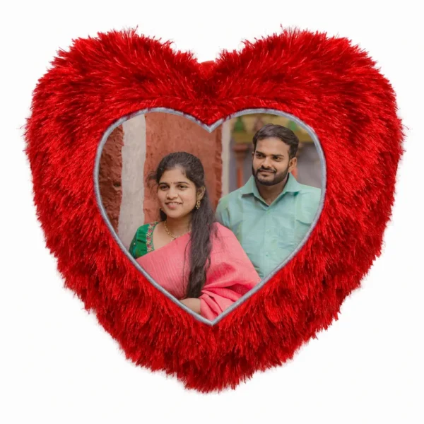A close-up product shot of a personalized red heart-shaped fur cushion featuring a custom photo of a couple in traditional wear by upahar18.