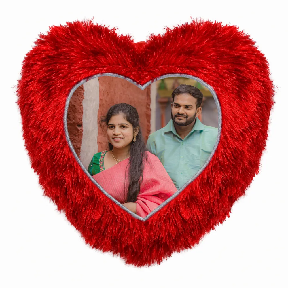 A close-up product shot of a personalized red heart-shaped fur cushion featuring a custom photo of a couple in traditional wear by upahar18.