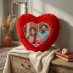 A decorative personalized red heart fur cushion with a custom photo displayed on a wooden chest in a styled room by upahar18.
