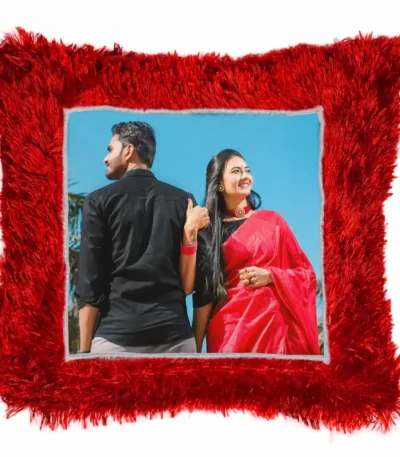 A close-up product shot of a personalized red square-shaped fur cushion with a couple's custom photo by upahar18.