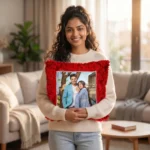 A woman holding a personalized red square-shaped custom photo fur cushion in a brightly lit modern living room by upahar18.