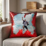 A lifestyle display of a personalized red square magic cushion with a custom photo on a couch next to premium upahar18 gift packaging.