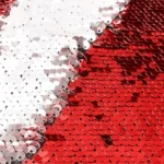A close-up macro shot of reversible red and white magic cushion sequins flipping over to reveal a personalized custom photo by upahar18.
