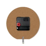 The back view of a round upahar18 MDF clock highlighting its raw brown fiberboard texture, a central black quartz movement box, and a silver metal stand pin.