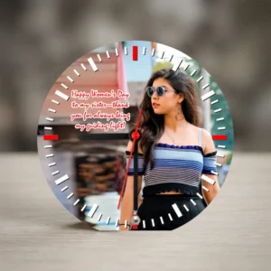 A round-shaped MDF clock from upahar18 standing on a wooden table, featuring a printed custom photo of a woman in sunglasses alongside a colorful Women's Day greeting.