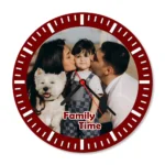A crisp studio front view of a circular upahar18 Wall clock printed with a high-definition custom photo of a mother and father kissing their child alongside a white pet dog, isolated on a solid white background.